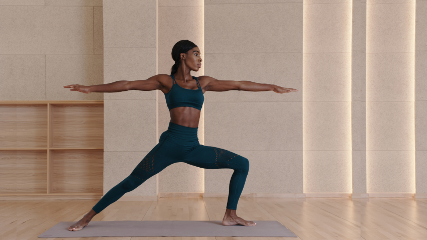 The transformational benefits of practicing yoga in Warrior II Pose (Virabhadrasana II) Black yoga teacher practicing Warrior II Pose (Virabhadrasana II)