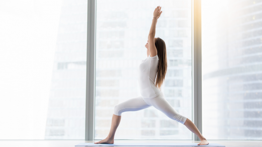 A yoga woman in Warrior 1 Pose (Virabhadrasana I) for strength and stability A yoga woman in Warrior 1 Pose (Virabhadrasana I) for strength and stability