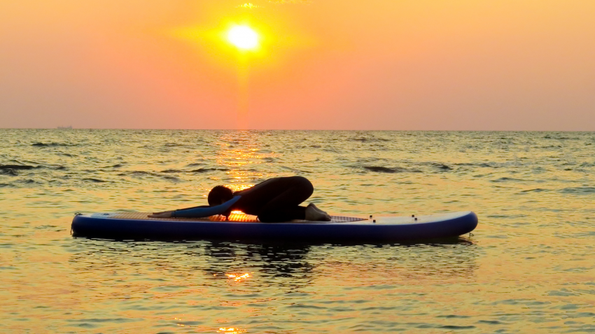 How to practice yogic principles of cultivating self-awareness on-and-off the mat in Child's Pose (Balasana) A yoga practitioner practicing Child's Pose (Balasana) on a kayak to benefit of self-awareness