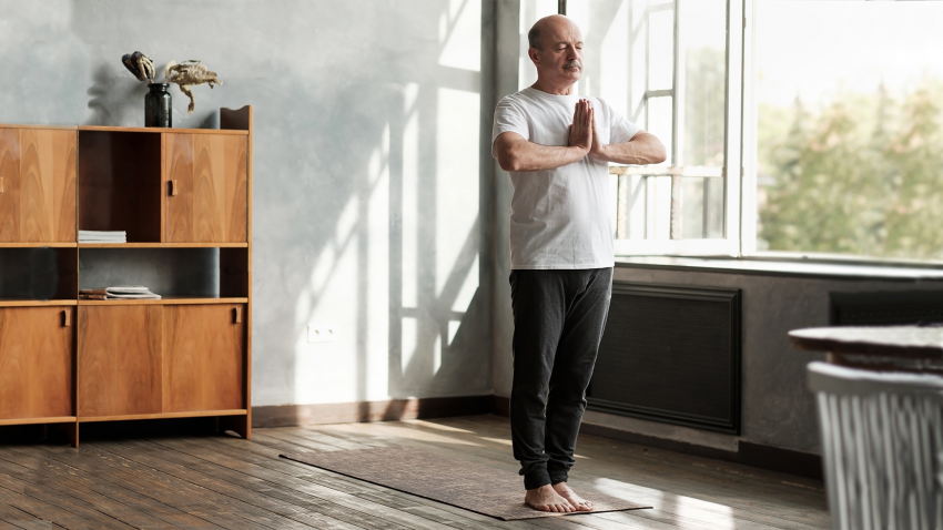 Older man practicing yoga in Mountain Pose (Tadasana) Older man practicing yoga in Mountain Pose (Tadasana)