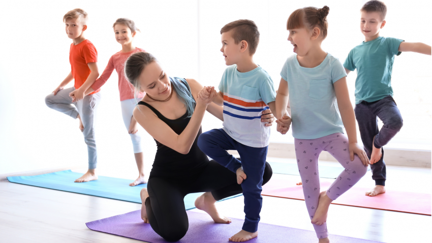 Yoga class for kids in school practicing Tree Pose (Vrkasana) Yoga class for kids in school practicing Tree Pose (Vrkasana)