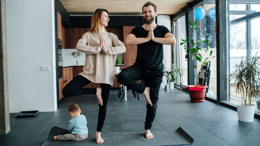 Family practicing yoga in Tree Pose (Vrksasana)