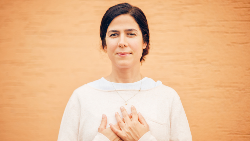 yoga woman standing calm with hands over heart in self-acceptance yoga woman standing calm with hands over heart in self-acceptance