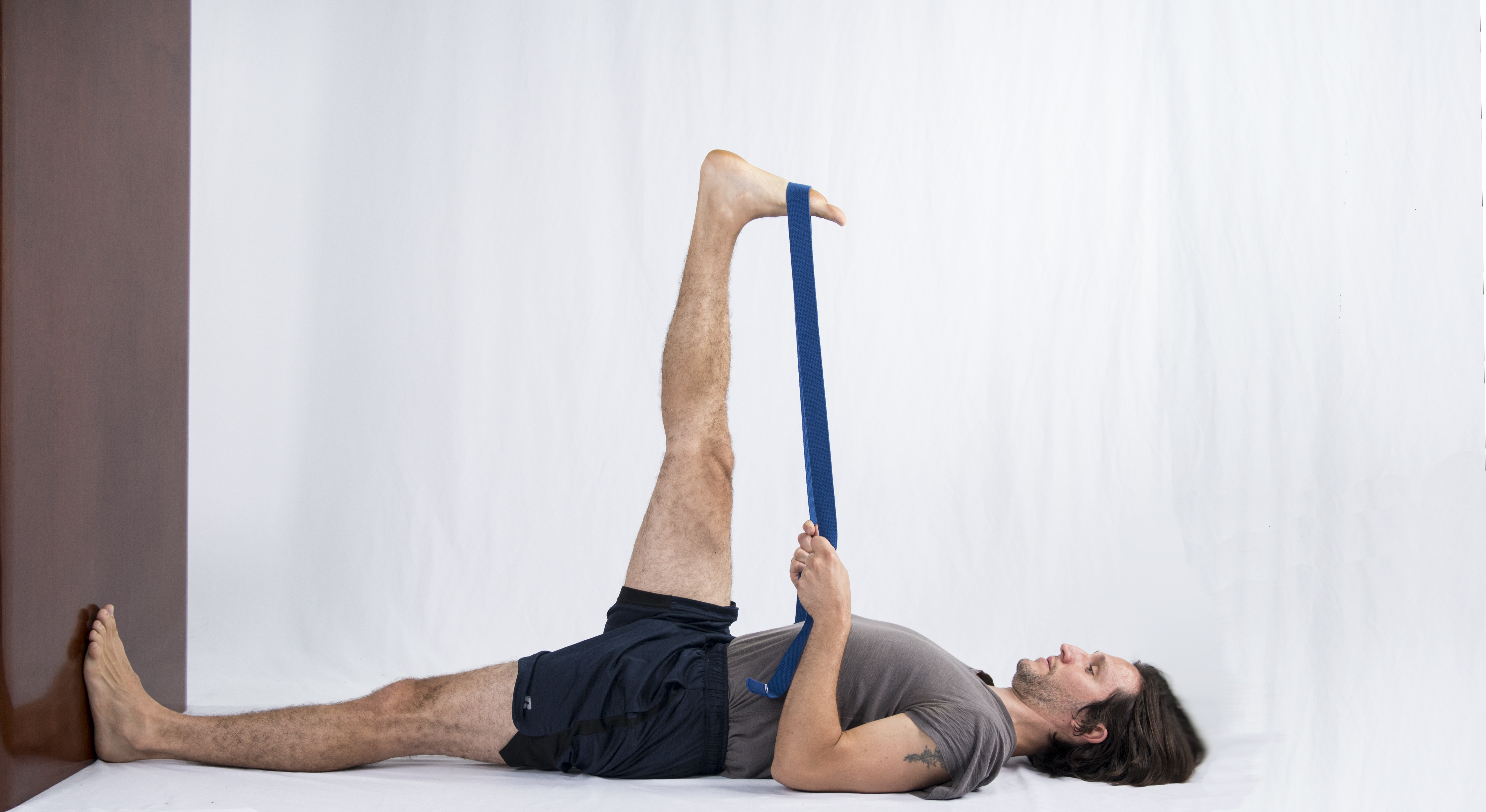 Supta Padangusthasana at the wall, hand to big toe pose at the wall, asana variations support at the wall, alignment with help of the wall